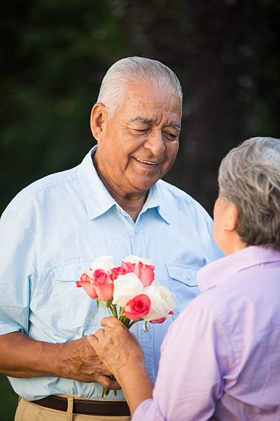 istock Senior husband giving wife flowers 500806297