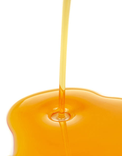 Stream of Pouring Syrup on White Background stock photo