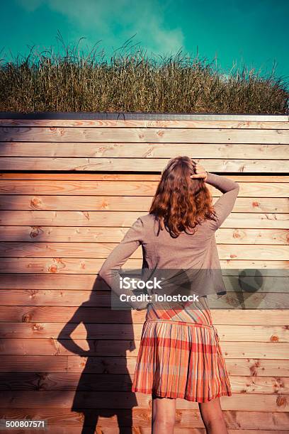 Young Woman Standing In Garden Outside Cabin Stock Photo - Download Image Now - Adult, Adults Only, Arts Culture and Entertainment