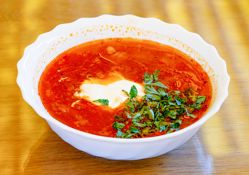 Plate of borscht with sour cream and fresh herbs