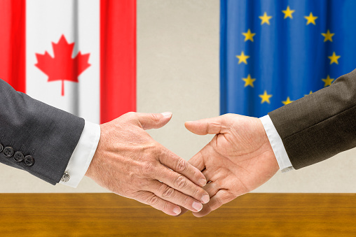 Representatives of Canada and the EU shake hands