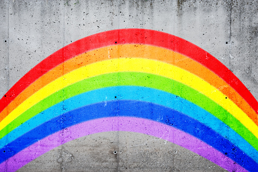 Rainbow painted on concrete wall.