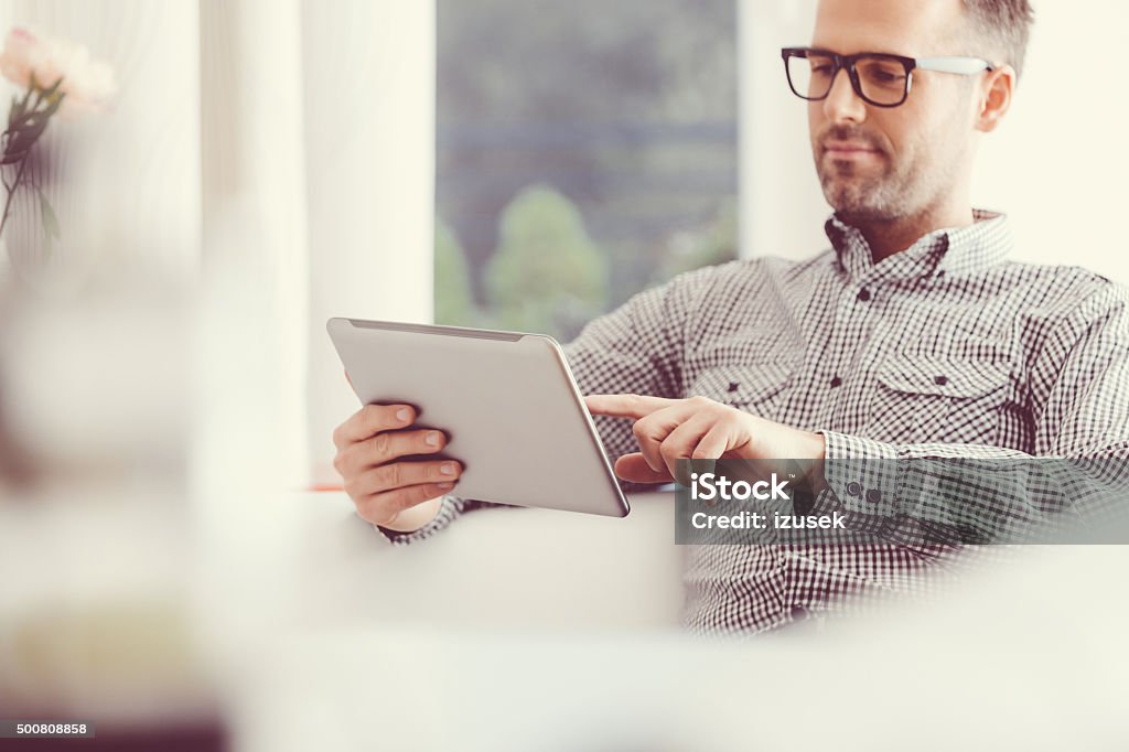 Hombre usando una tableta digital en su hogar - Foto de stock de Tableta digital libre de derechos