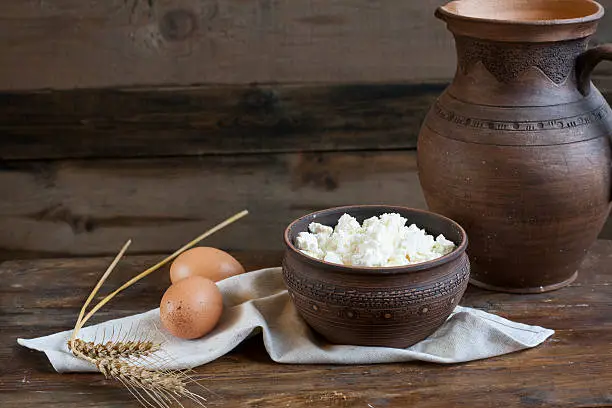 Culinary cottage cheese in a clay bowl on dark wooden table