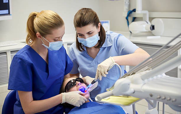 femme de dentistes traitant patient de dents femme - dental assistent photos et images de collection