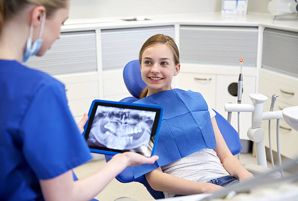 zahnarzt mit x-ray auf tablet pc und geduldig mädchen - teenager dentist patient cheerful stock-fotos und bilder