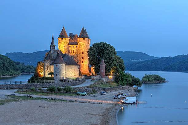 Auvergne, France - July 13, 2013: Chateau de Val in Auvergne, France at twilight overlooking the artificial lake surrounding it.