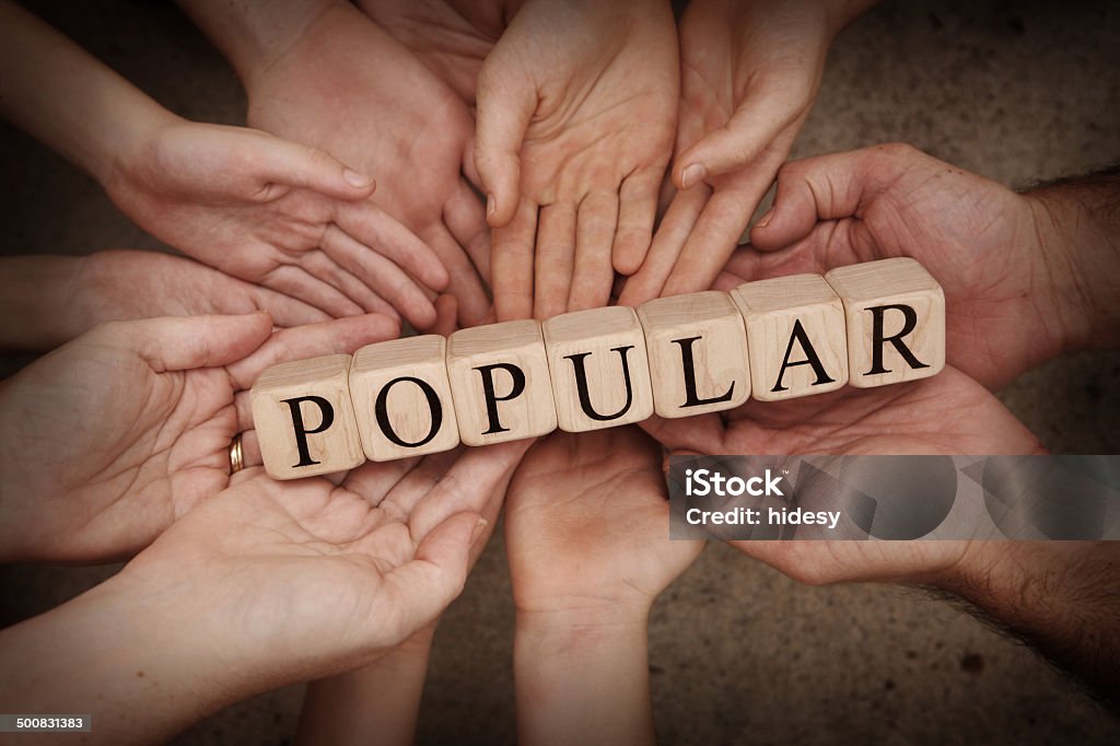 Getting Popular Lots of people all holding blocks spelling out popular Child Stock Photo