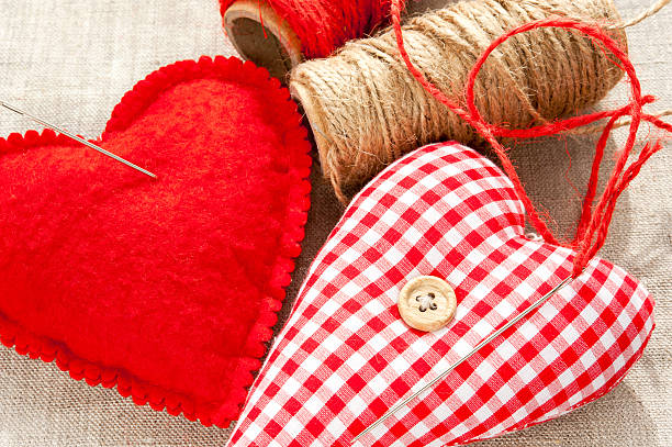 dos caseras textil sewed rojo de algodón amor corazón. en primer plano. - heart shape pillow cushion textile fotografías e imágenes de stock