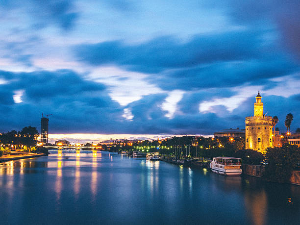 siviglia, river al crepuscolo - seville sevilla torre del oro tower foto e immagini stock