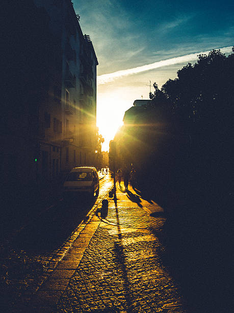 Woman walking on the sidewalk at sunset. Location: Sevilla, Spain.