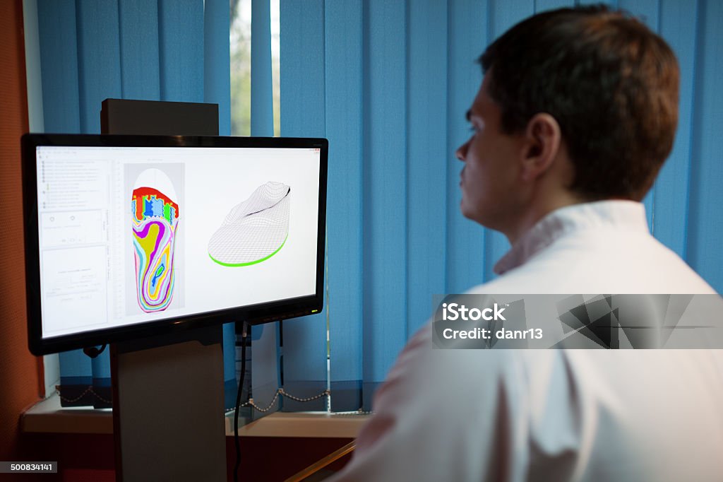 Orthopaedist at work with digital footstep model Orthopaedist at work with computer. He modeling orthopedic shoe using foot scan Medical Scan Stock Photo