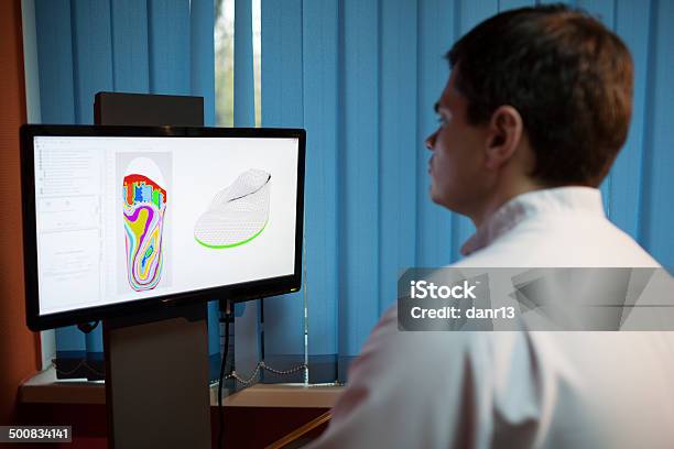 Orthopaedist At Work With Digital Footstep Model Stock Photo - Download Image Now - Medical Scan, Medical Scanner, Orthopedic Equipment