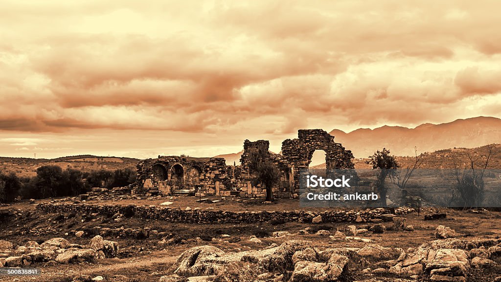 Ancient Troizina Ruins monochrome based on red, Greece Pillar ruins at Ancient Troizina at dramatic sky, Peloponnese, Greece Ancient Stock Photo