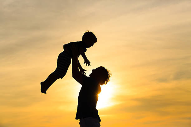istock father and little son silhouettes play at sunset 500836852