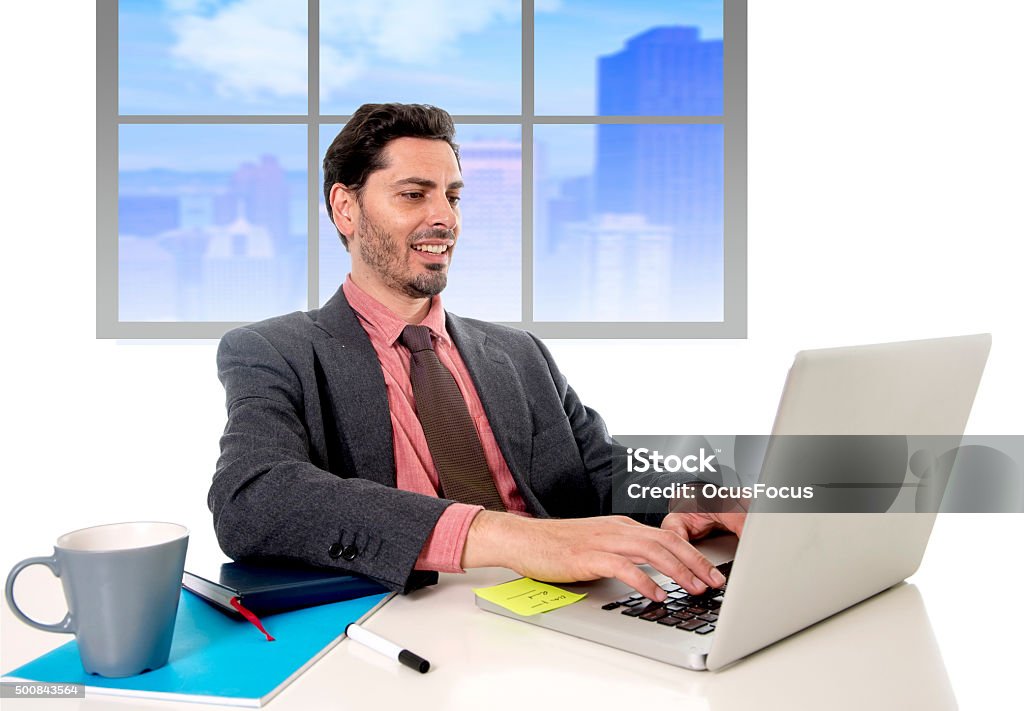 businessman working at office computer happy satisfied and successful young handsome businessman working at business district office typing on  computer laptop looking happy satisfied and relaxed in work success concept 2015 Stock Photo