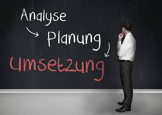 istock Businessman looking at a chalkboard of german planning terms 500846065