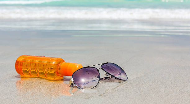 istock Sunscreen lotion and dark glasses on the beach 500847799