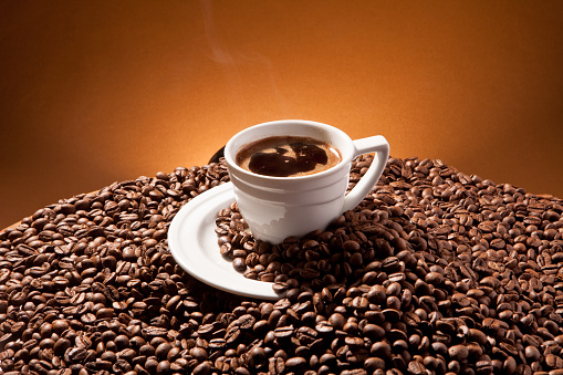 Cup of coffee and coffee beans on the background