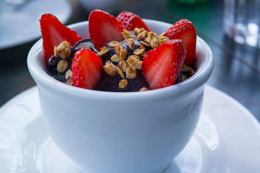 Bowl of Acai pulp with strawberries and granola. Acai or Açai is a tradicional berry from Amazon rainforest, Brazil.