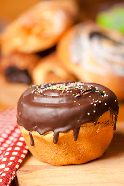 Close Up Dessert Roll with Cream and Chocolate Balls on Wooden Plate Top View