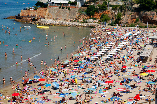 People relaxing and having fun on the beach of Salou, Spain