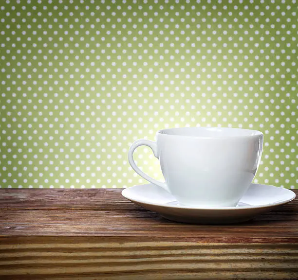 Coffee cup over green polka dots background