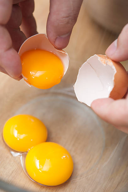 istock cracking eggs and seperate yolk from albumen 500870635
