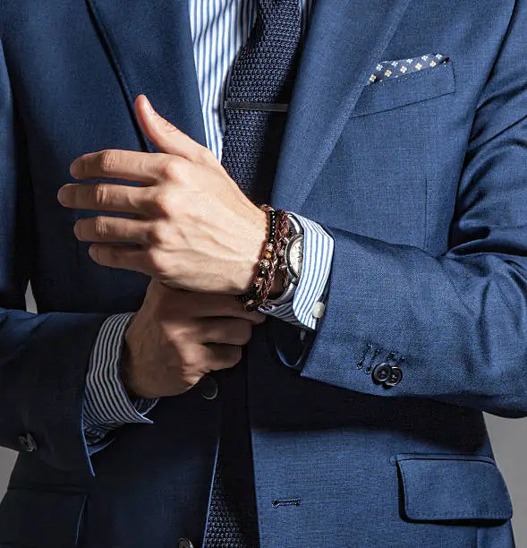 Suave modern man in casual style with bracelets on hand