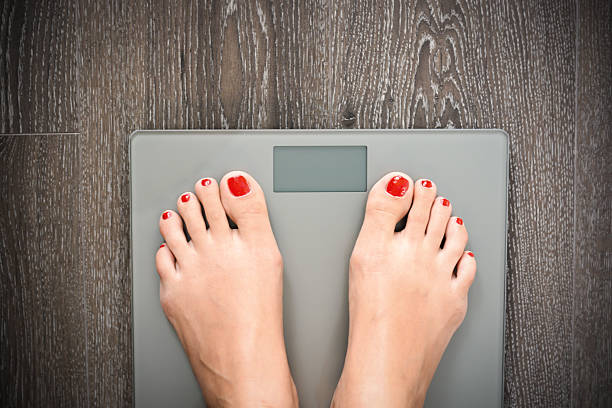 istock Lose weight concept with person on a scale measuring kilograms 500874680