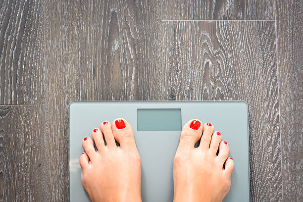 istock Lose weight concept with person on a scale measuring kilograms 500874716