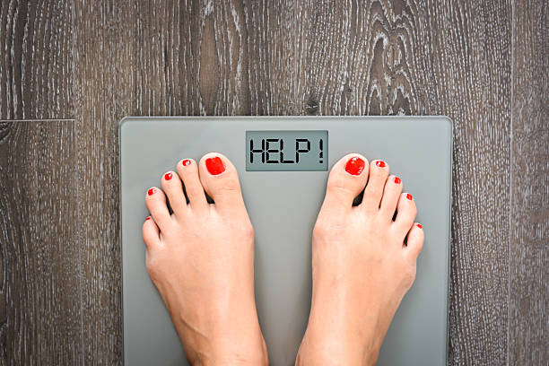 Lose weight concept with person on a scale measuring kilograms stock photo