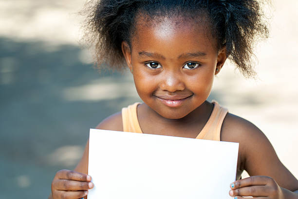 istock African girl holding white card. 500875407