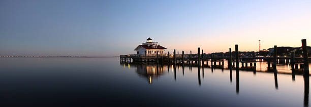 Lighthouse reflected in water at dusk Roanoke Marshes Lighthouse Manteo NC Outer Banks North Carolina dock in Albemarle Sound cape hatteras stock pictures, royalty-free photos & images