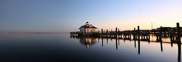 Photo of Lighthouse reflected in water at dusk