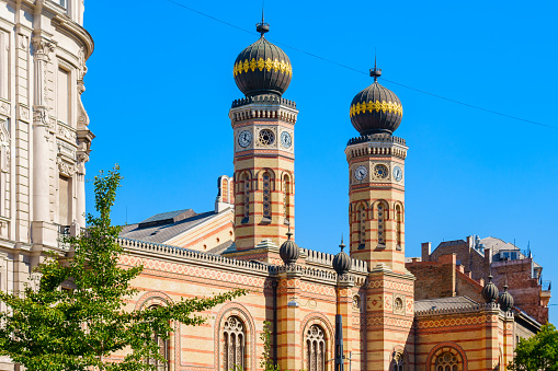 Photo of the facade of the Great Synagogue aka as the Dohany Street Synagogue in Budapest, Hungary on a blue sky day.