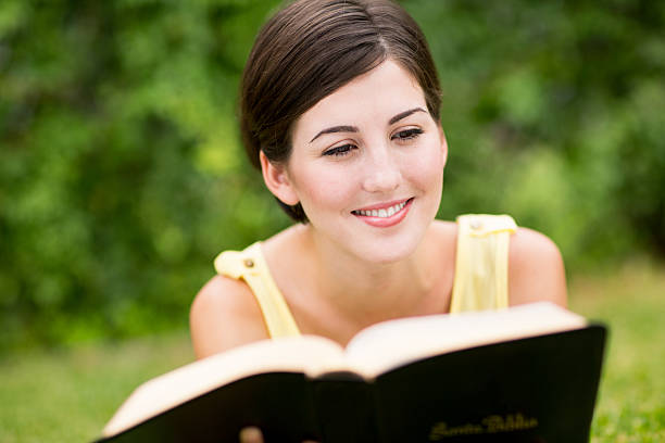 istock Latin woman reading bible on grass 500885033
