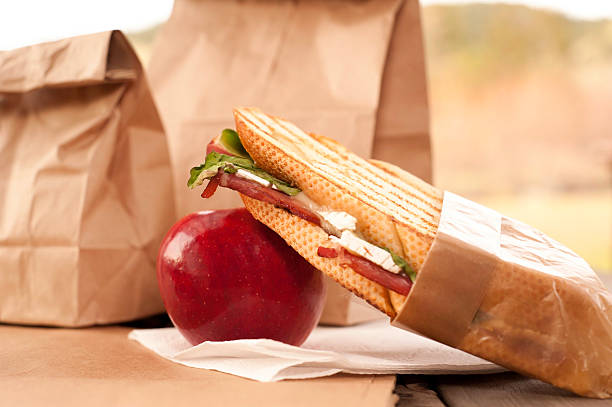 коричневый бумажный мешок обеда яблоко-стоковое изображение - lunch bag apple brown стоковые фото и изображения