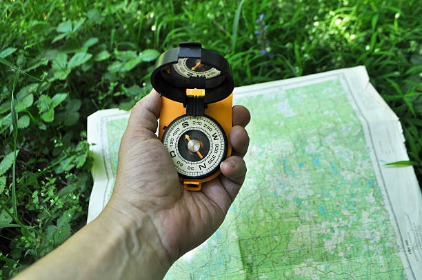compass in der hand gegen hintergrund der karte. - boy scout orienteering compass map stock-fotos und bilder