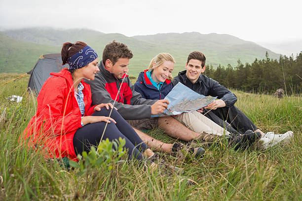 istock Friends sitting on grass and looking at map 500889071