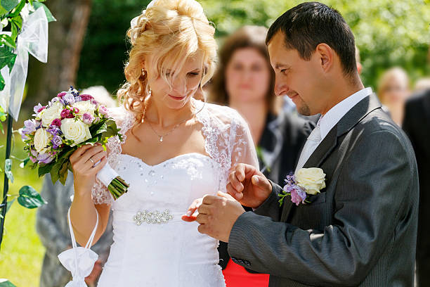 istock beautiful young wedding couple exchange wedding rings 500889429