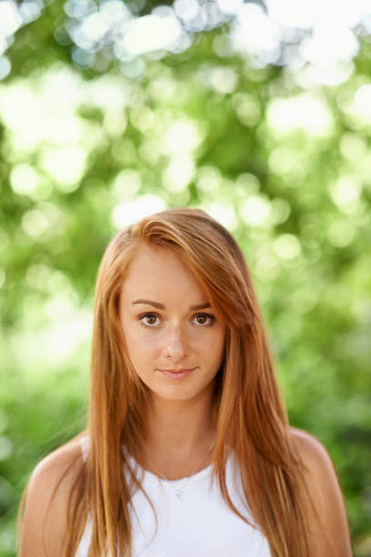 Candid shot of a young woman outdoor with selective focus near the forest