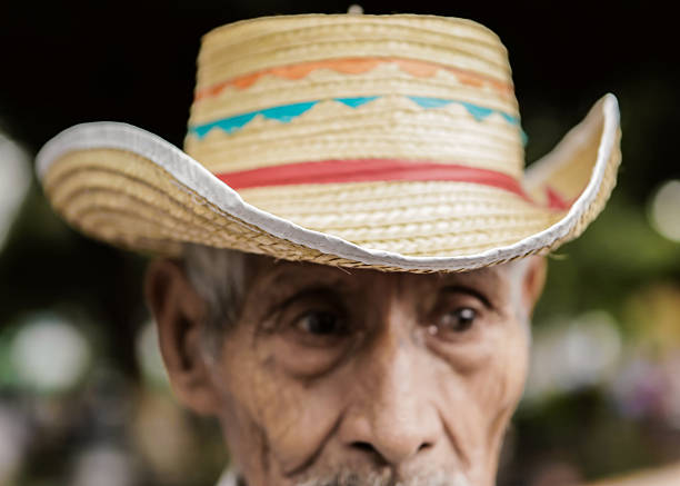 Santa Tecla, El Salvador - September 26, 2015: Street portrait of a senior indigenous Salvadoran man wearing a straw hat in a local market. 