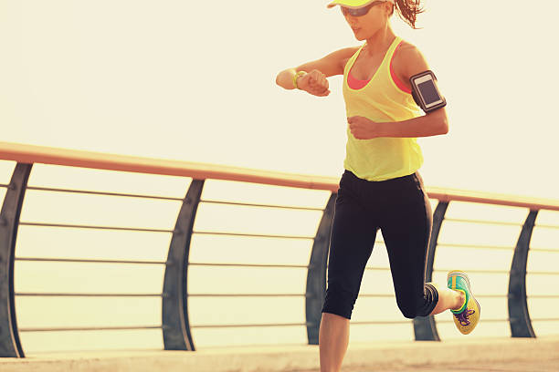istock woman runner checking her running time from smart watch 500897700