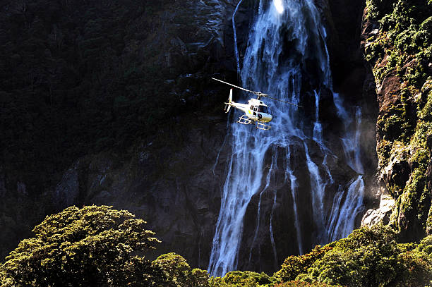 New Zealand Fiordland A helicopter flies over Fiordland, southern New Zealand. milford sound stock pictures, royalty-free photos & images