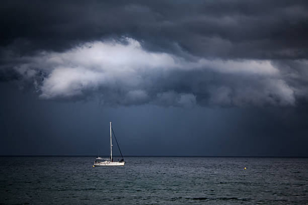 barca vele sotto le nuvole tempestose - occhio del ciclone foto e immagini stock