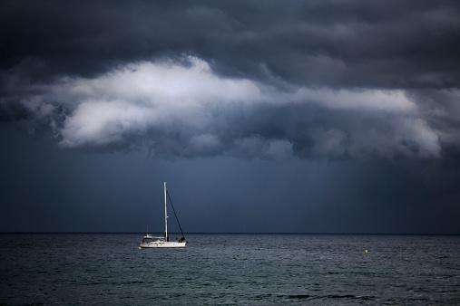 The boat sailing in the sea and the threatening storm is coming