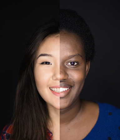 Portrait of young asian and african descent woman with black background.