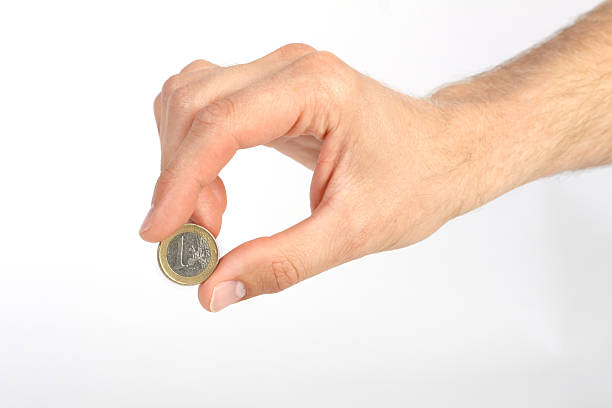 istock Man's hand holding one euro coin on white background 500909015