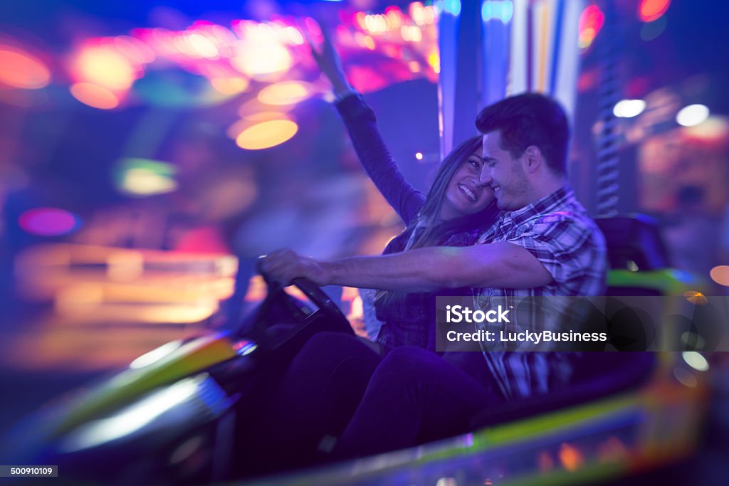 Couple having fun in bumper car Young couple having fun in bumper car Adult Stock Photo
